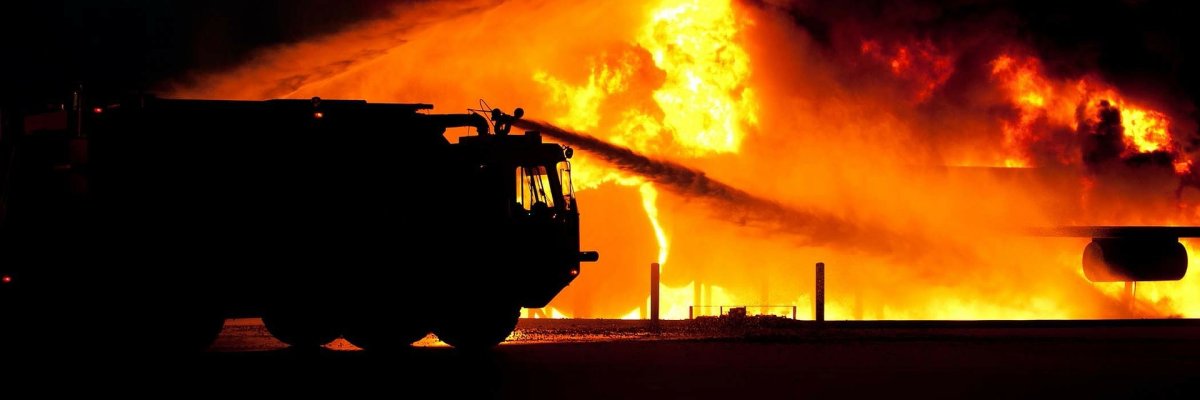 Feuerwehrauto steht vor einer brennenden Fläche