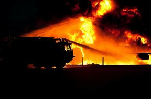 Feuerwehrauto steht vor einer brennenden Fläche
